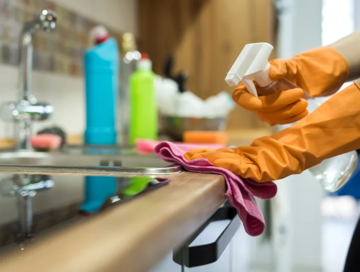 woman-while-cleaning-surface-kitchen-desk-with-sponge-her-rubber-gloves-housework